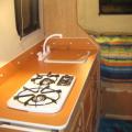 Inside our 2011 Escape19: Atomic Orange Formica, switched stove and sink, eliminated range hood.